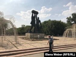 Шахтер ескерткіші қасынан өтіп бара жатқан адам. Қарағанды, 29 шілде 2019 жыл.